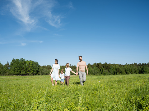 Family of parents and children Enjoying Walk In Beautiful Countryside