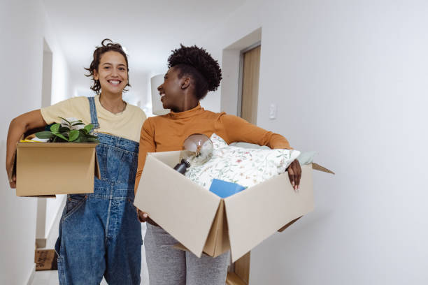 istock Cheerful friends carrying cardboard boxes with belongings 1413463092