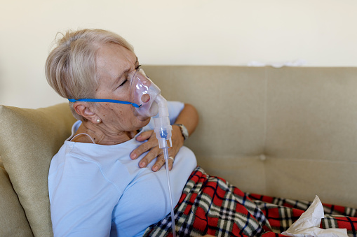 Woman patient on bed at home  with wearing oxygen mask