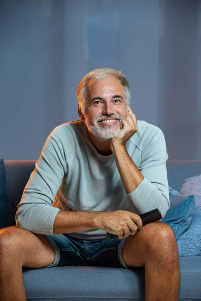 istock Mature man watching TV at home 1413464596