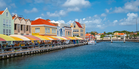 Landscape with colorful buildings and local market at the waterfront. Popular destination for tourists. It used to be a floating fish market. Curacao, Netherlands Antilles, Leeward Islands, Caribbean.