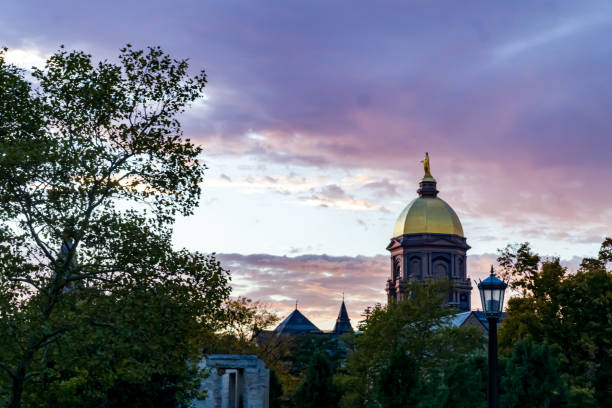 Notre Dame at Dusk Golden Dome on the Main Building at the University of Notre Dame at Dusk south bend stock pictures, royalty-free photos & images