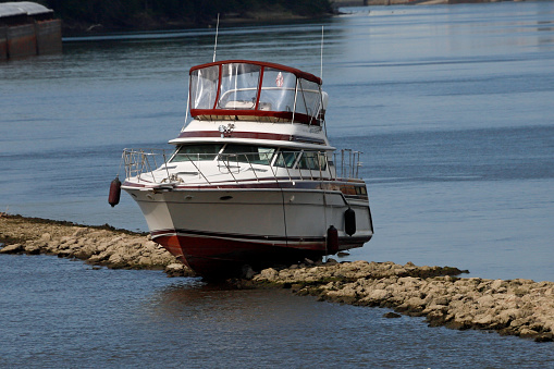 expensive pleasure boat grounded on rocky shoal