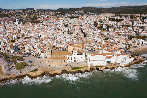 Aerial view of Sitges small town with Monastery on Mediterranean coastline, Spain