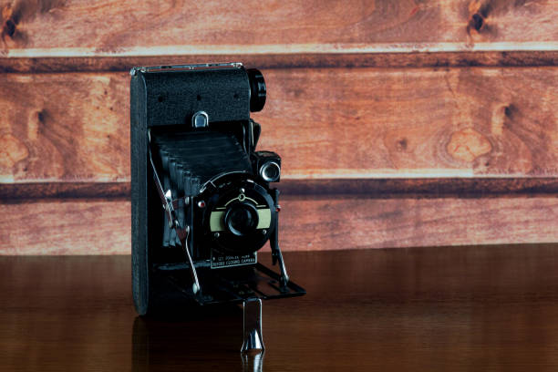 istock Antique Folding Camera on a Varnished Wooden Shelf 1413469683