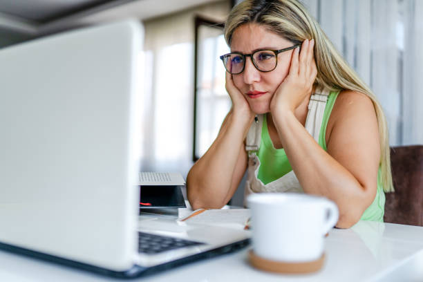 Adult woman taking online lessons at home and struggling stock photo
