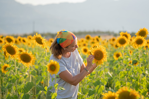 Happy farmer woman in sunflower field