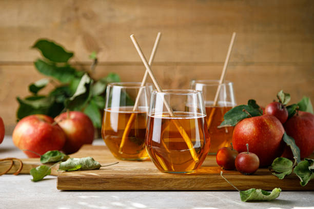 Apple juice in a glass and fresh fruits with leaves Apple juice in a glass and fresh fruits with leaves apple juice photos stock pictures, royalty-free photos & images