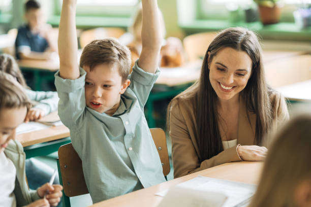 istock Elementary schoolboy looking excited after finishing his exam paper in classroom 1413476444