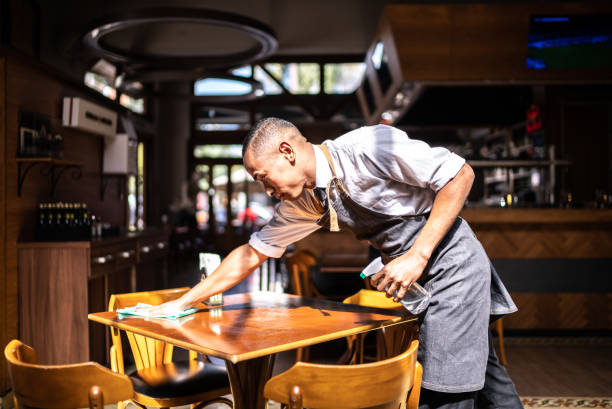 istock Waiter cleaning a dining table at a restaurant 1413476508