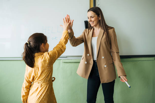 istock Happy female teacher giving high-five to elementary student 1413479166