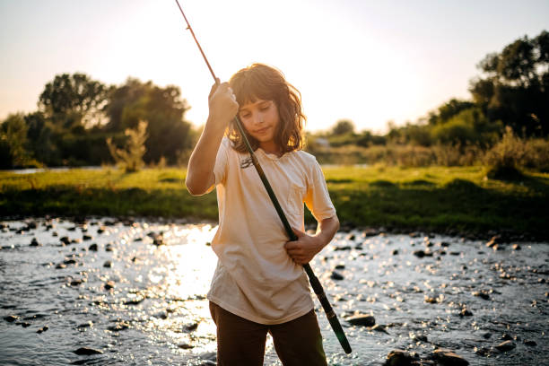 istock Boy fishing on the river 1413480241