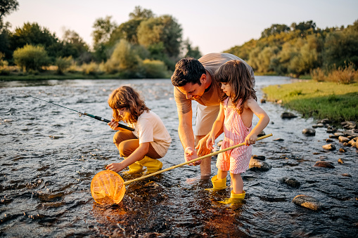 Father with two sons collects pebbles