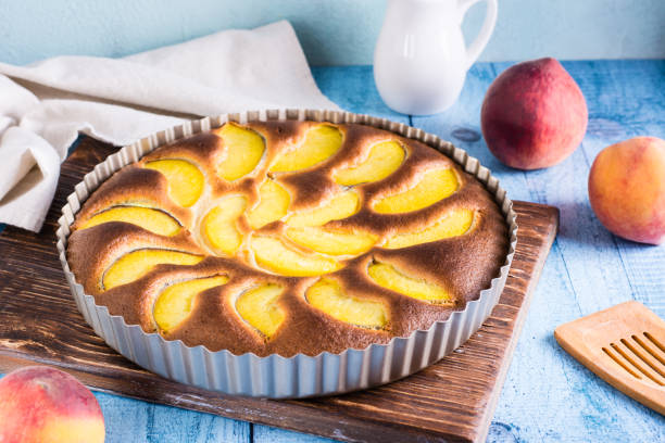 istock Ready fresh peach pie in a baking dish on the table. Homemade dessert 1413481700