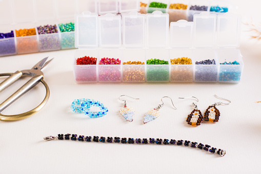 Containers with colored beads and accessories for making jewelry from beads. Needlework and handmade