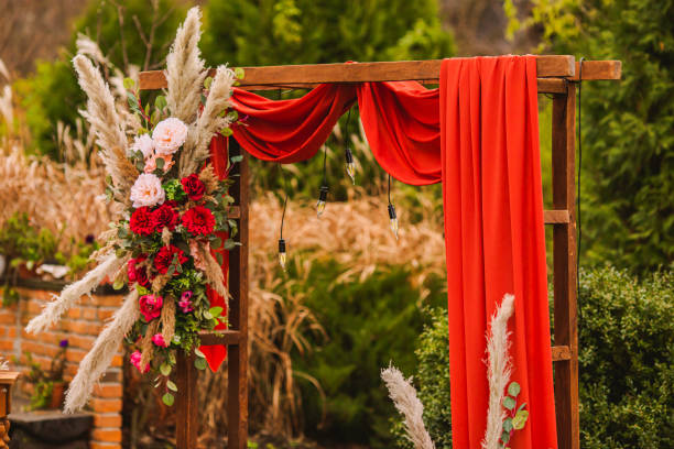 istock Wedding arch in boho style with flowers and light bulbs. Autumn wedding ceremony. Decor. Rustic 1413483225