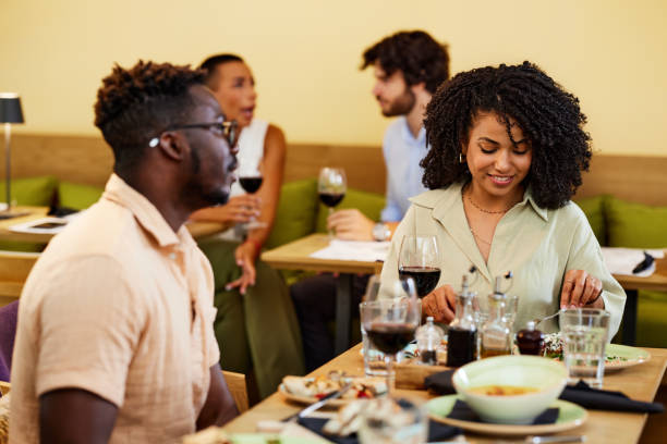 istock A multicultural couple sits in a restaurant during dinner and eats food together. 1413487721