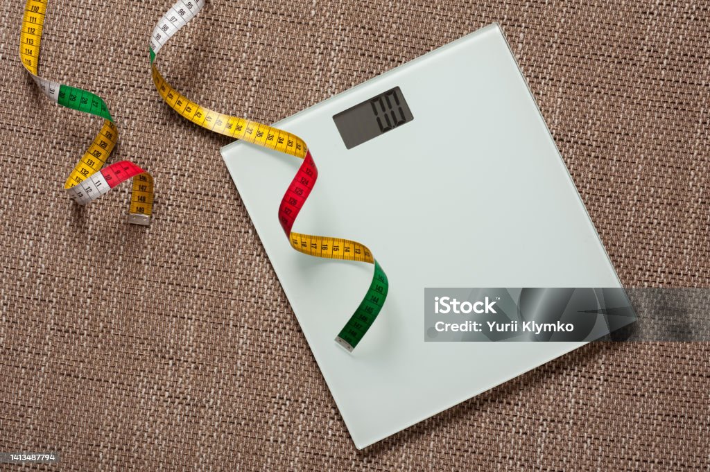 electronic scale electronic scale and elastic ruler on the coarsely woven fabric background Above Stock Photo