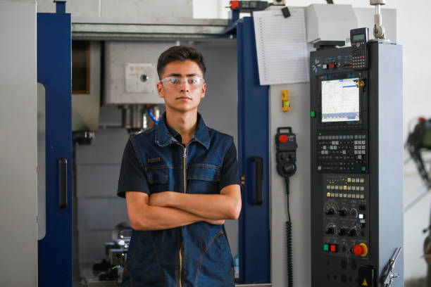 istock young man cnc milling machine operator stands in front of the machine with his arms folded. 1413493382