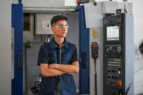 istock young man cnc milling machine operator stands in front of the machine with his arms folded. 1413493409