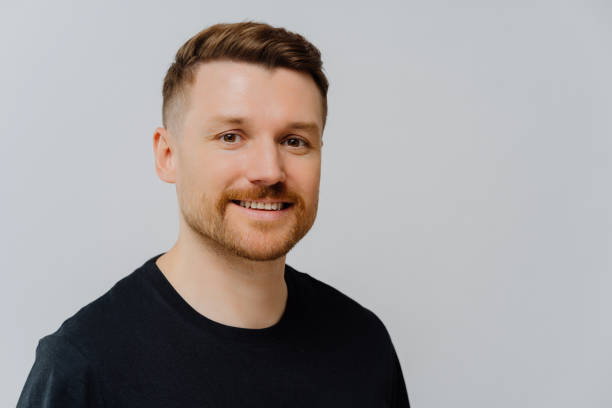 istock Handsome unshaven man smiling at camera and expressing positivity 1413493877