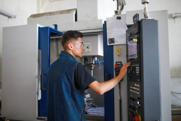 young man works on cnc machine. young start-up - ncc imagens e fotografias de stock