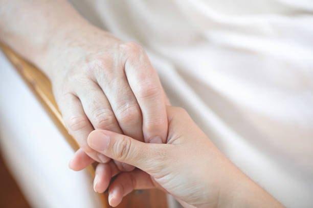 Parkinson disease patient, Alzheimer elderly senior, Arthritis person hand in support of nursing family caregiver stock photo