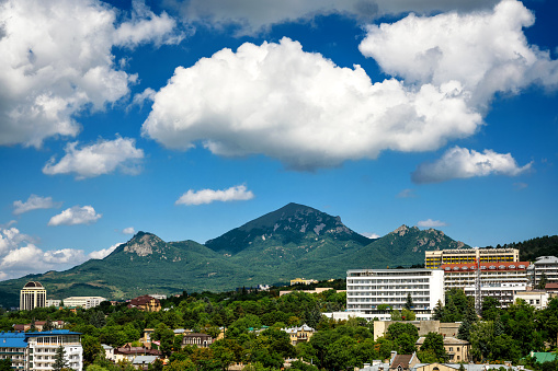 Landscape of Pyatigorsk, view of Beshtau Mount under beautiful clouds, Russia. This mountain is landmark of Stavropol Krai. Scenery of Pyatigorsk and blue sky in summer. Nature and tourism theme.