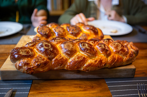 Ripped challah on a cutting board.