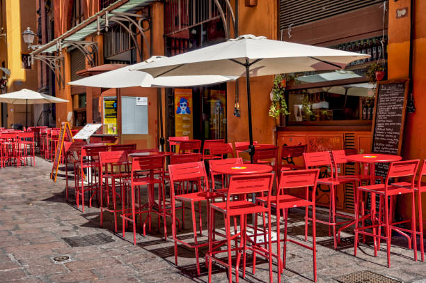 A view of chairs and tables outside a typical old-fashioned cafe in the historic Montmartre area of Paris.\nSelective focus, with only the foreground table in focus.