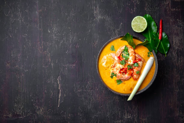 shrimps tom yam kung in grey bowl with thai spices on autentic tray top view, wooden background. - sopa tom yum imagens e fotografias de stock