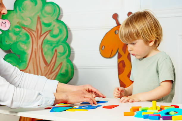 istock Boy with adult in kindergarten put figures on the table 1413507249
