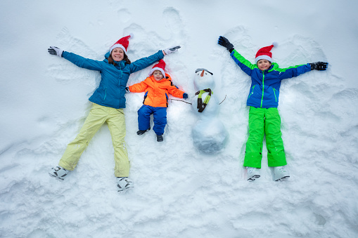 Portrait of happy family enjoying snowball fight in beautiful winter forest, focus on bearded man in foreground, copy space