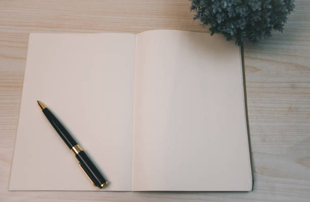 istock Notebooks and diary pen and planner top view wood background. 1413508380