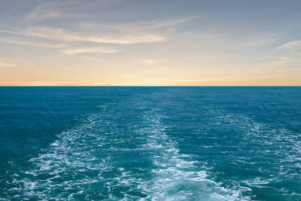 Water surface behind of fast moving motor boat with sunset sky.
