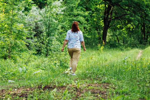 A young Caucasian woman enjoying a walk in the woods