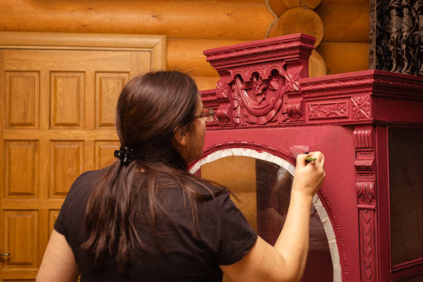 armário de envelhecimento lady com ornamentos de madeira esculpidos pintando-o na cor vermelha com pincel. processo de patinação de móveis. reutilização ecológica. coisas velhas ganhando vida nova - patination - fotografias e filmes do acervo