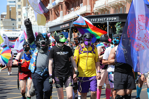 Brighton, England - August 6th 2022: Participants wearing leather dog heads attending the Gay Pride parade.\nOne of the UK's most significant pride events is celebrating its 30th anniversary. Brighton & Hove Pride is intended to celebrate, and promote respect for, diversity and inclusion within the local community and support local charities and causes through fundraising.