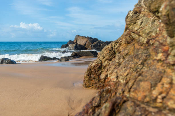 istock A wave breaks about a rock during a curtain on the sea. 1413515713