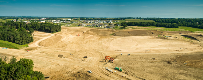 Panoramic drone shot of newly graded land being prepared for housing in Deforest, Wisconsin on a summer day.