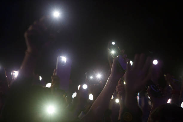 istock People holding smart phone with flash on and hands up 1413518495