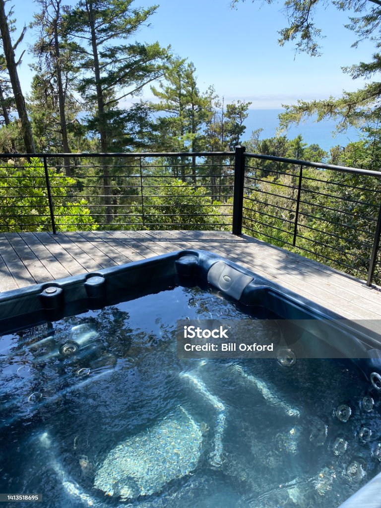 Hot tub on deck by ocean with railing in California Hot Tub Stock Photo