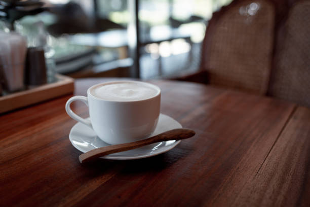 istock Coffee cup on wooden table in cafe with lighting background 1413519532