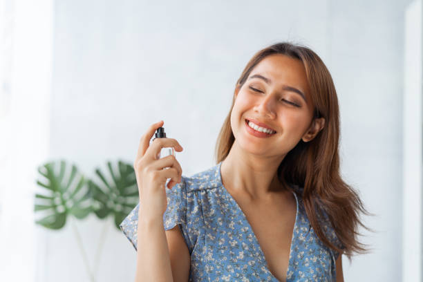 istock Young pretty Asian woman working as beauty vlogger using perfume. 1413520743