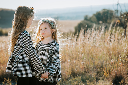 Portrait of Little Girls holding hands and looking at each other with copy space