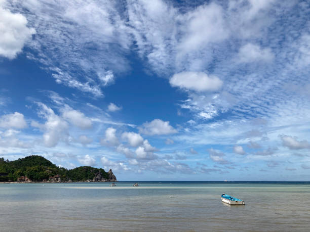 istock Small rowing boat floating in the sea and blue sky background. 1413529489