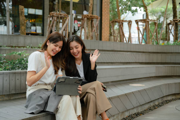 istock Two Asian Businesswomen take a break while working in a comfortable park 1413530307