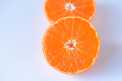 Sliced mandarin oranges on white background.\nJapanese fruit.