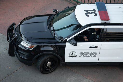 Santa Ana, California, USA - November 6, 2021:  A Santa Ana Police cruiser idles on a street corner.