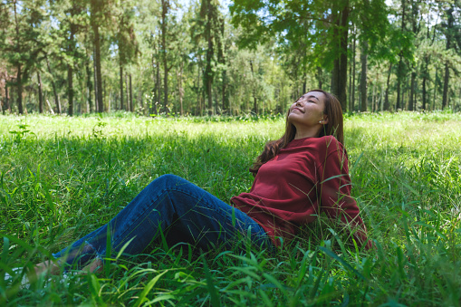 Portrait image of a beautiful young asian woman with closed eyes sitting in the park